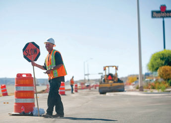 Matthew Garcia waves through traffic in the midst of construction for road improvements on Maloney near Wal-Mart on Thursday. © 2011 Gallup Independent / Adron Gardner 